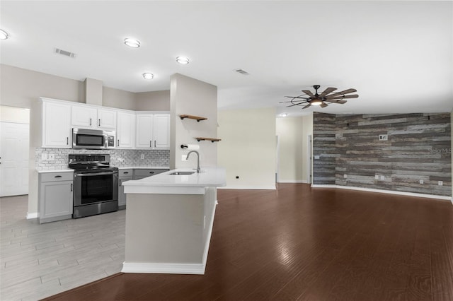 4305 Heyward St, North Port, FL 34291 - kitchen featuring stainless steel appliances, a sink, ceiling fan, light wood-style floors, and light countertops