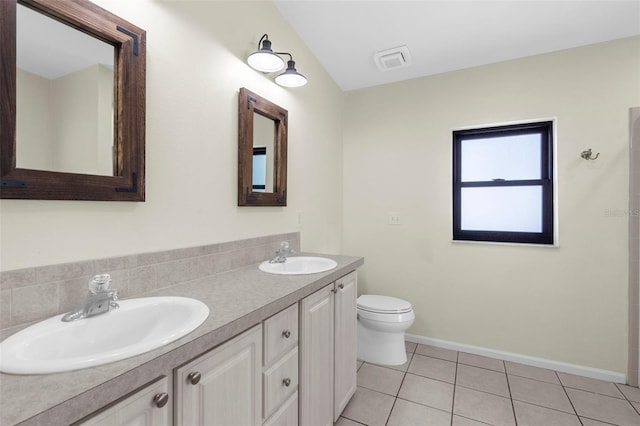 4305 Heyward St, North Port, FL 34291 - bathroom featuring toilet, double vanity, tile patterned floors, and baseboards