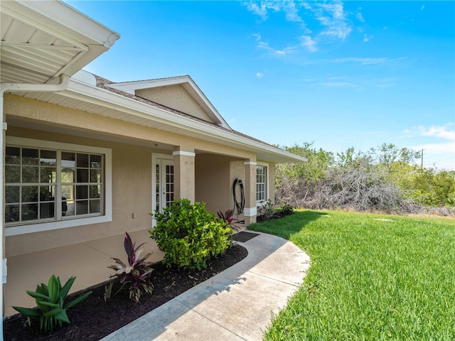 6199 Stamp St, Port Charlotte, FL 33981 - doorway to property with stucco siding and a yard