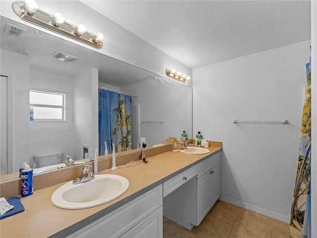 6199 Stamp St, Port Charlotte, FL 33981 - full bath with double vanity, toilet, tile patterned flooring, a textured ceiling, and a shower with shower curtain