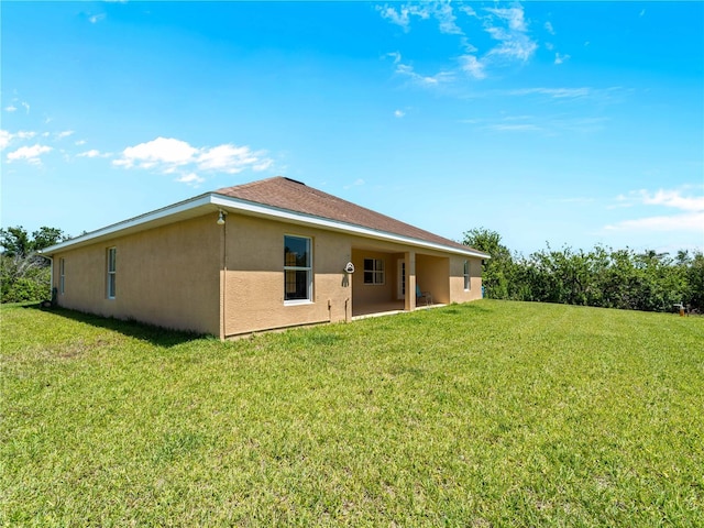 6199 Stamp St, Port Charlotte, FL 33981 - back of house with stucco siding and a yard