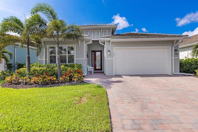 629 Ibiza Loop, Venice, FL 34292 - view of front facade with decorative driveway, stucco siding, a garage, and a front lawn
