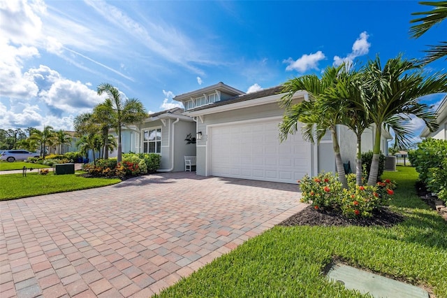 629 Ibiza Loop, Venice, FL 34292 - view of front of house with stucco siding, decorative driveway, an attached garage, and a front yard