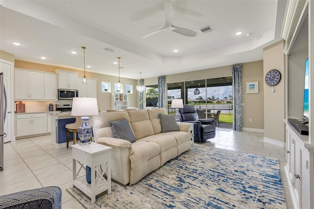 629 Ibiza Loop, Venice, FL 34292 - living area featuring light tile patterned flooring, ceiling fan, recessed lighting, baseboards, and a raised ceiling