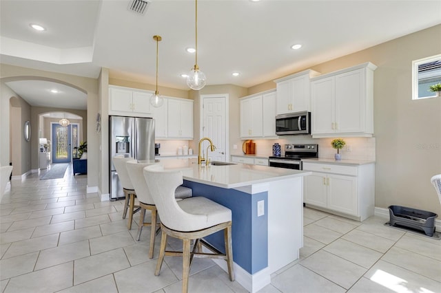 629 Ibiza Loop, Venice, FL 34292 - kitchen with appliances with stainless steel finishes, a sink, decorative backsplash, a kitchen breakfast bar, and an island with sink