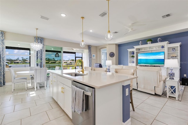 629 Ibiza Loop, Venice, FL 34292 - kitchen with stainless steel dishwasher, a sink, white cabinetry, open floor plan, and light tile patterned flooring