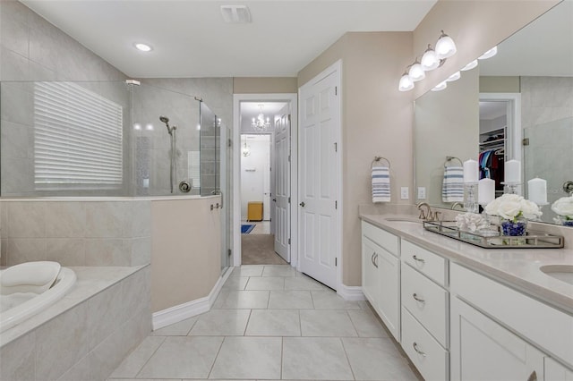 629 Ibiza Loop, Venice, FL 34292 - bathroom with a stall shower, double vanity, a walk in closet, and tile patterned floors