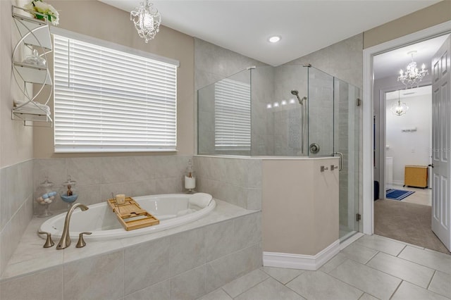 629 Ibiza Loop, Venice, FL 34292 - bathroom with a chandelier, a bath, a stall shower, and tile patterned flooring