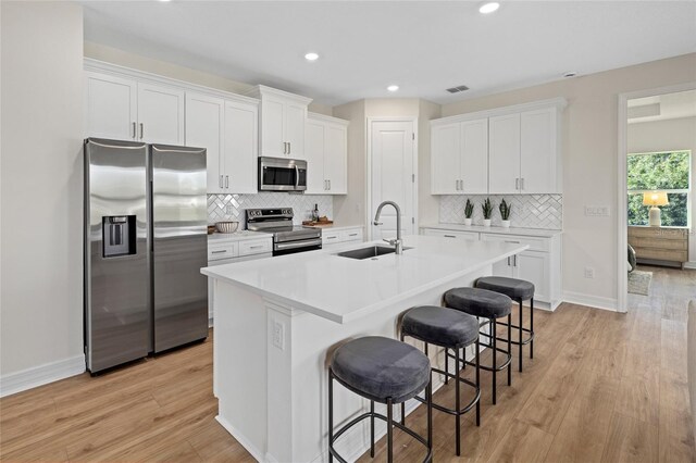 4390 Asteria Ter, North Port, FL 34287 - kitchen with stainless steel appliances, a sink, an island with sink, white cabinets, and recessed lighting