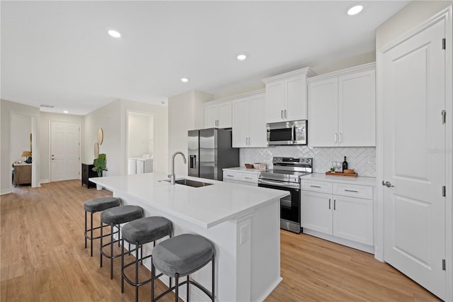 4390 Asteria Ter, North Port, FL 34287 - kitchen featuring stainless steel appliances, a sink, a kitchen breakfast bar, a kitchen island with sink, and tasteful backsplash