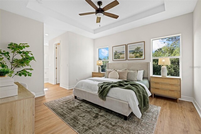 4390 Asteria Ter, North Port, FL 34287 - bedroom with a raised ceiling, light wood-type flooring, baseboards, and ceiling fan