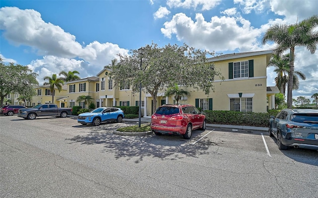 view of building exterior featuring uncovered parking and a residential view