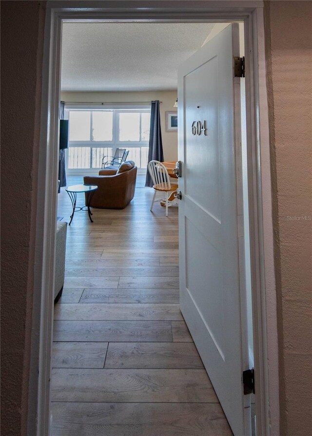 1255 Tarpon Center Dr Unit 604, Venice, FL 34285 - hallway featuring hardwood / wood-style floors and a textured wall