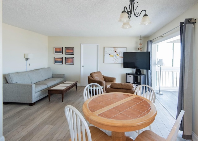 1255 Tarpon Center Dr Unit 604, Venice, FL 34285 - dining area featuring light wood-style flooring, a chandelier, and a textured ceiling