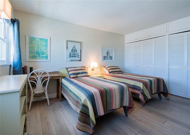 1255 Tarpon Center Dr Unit 604, Venice, FL 34285 - bedroom with light wood-style floors, a textured ceiling, and a closet
