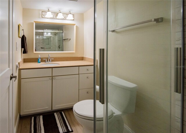 1255 Tarpon Center Dr Unit 604, Venice, FL 34285 - bathroom featuring toilet, a stall shower, wood finished floors, and vanity