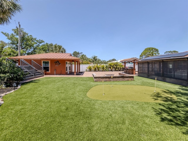 view of yard with an area to practice putting, a patio, and stairway