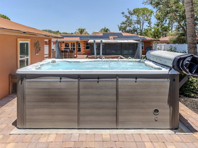 view of swimming pool with a hot tub