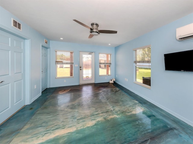 unfurnished living room with concrete flooring, a wall mounted air conditioner, a ceiling fan, baseboards, and recessed lighting