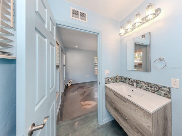 bathroom with finished concrete flooring, vanity, and decorative backsplash