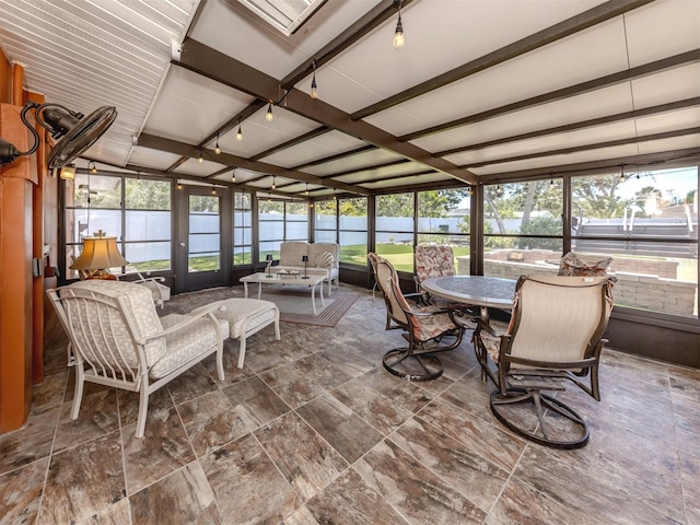 sunroom / solarium featuring beam ceiling, outdoor dining area, and healthy amount of natural light