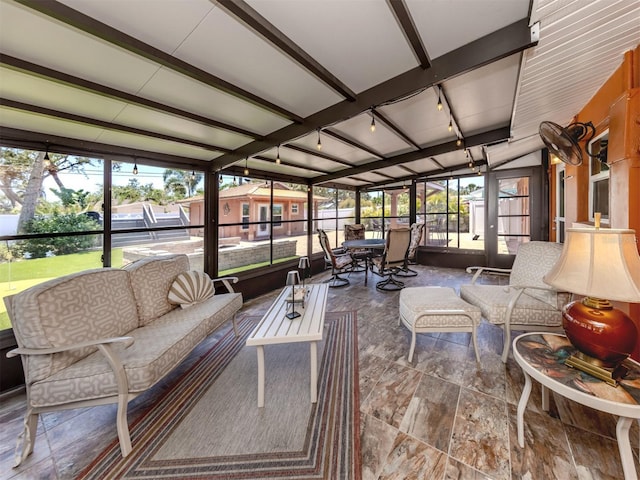 sunroom / solarium featuring an outdoor living space, beamed ceiling, and track lighting