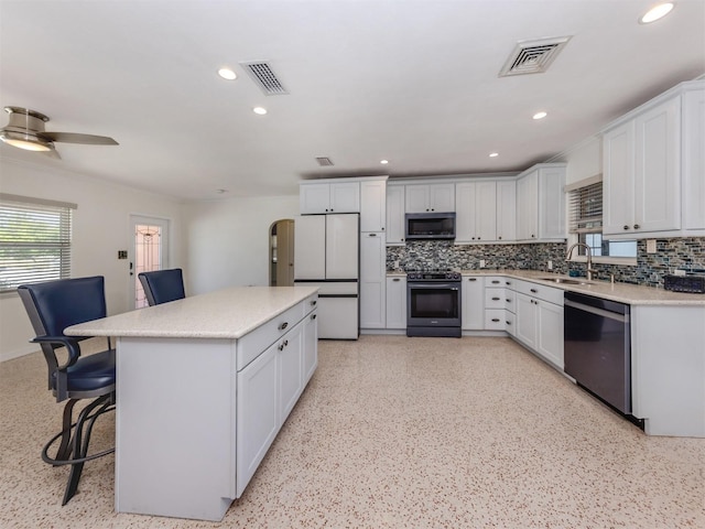 kitchen featuring appliances with stainless steel finishes, a sink, decorative backsplash, a breakfast bar area, and recessed lighting