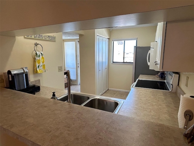 1154 Bird Bay Way Unit 303, Venice, FL 34285 - kitchen featuring a sink, white appliances, and light countertops