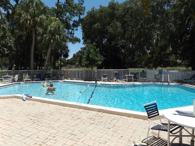 1154 Bird Bay Way Unit 303, Venice, FL 34285 - community pool with fence, view of wooded area, and a patio area