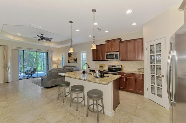 241 Marcheno Way, Nokomis, FL 34275 - kitchen featuring stainless steel appliances, open floor plan, ceiling fan, decorative backsplash, and a breakfast bar area