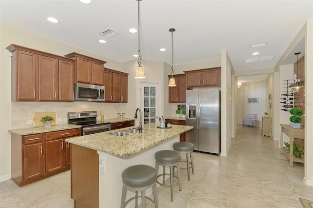 241 Marcheno Way, Nokomis, FL 34275 - kitchen with appliances with stainless steel finishes, a sink, tasteful backsplash, a kitchen bar, and light stone countertops