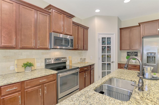 241 Marcheno Way, Nokomis, FL 34275 - kitchen with appliances with stainless steel finishes, a sink, backsplash, light stone counters, and recessed lighting