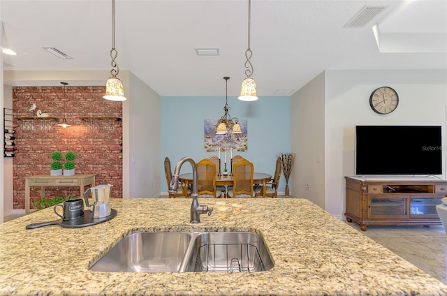 241 Marcheno Way, Nokomis, FL 34275 - kitchen with a sink, light stone counters, and pendant lighting