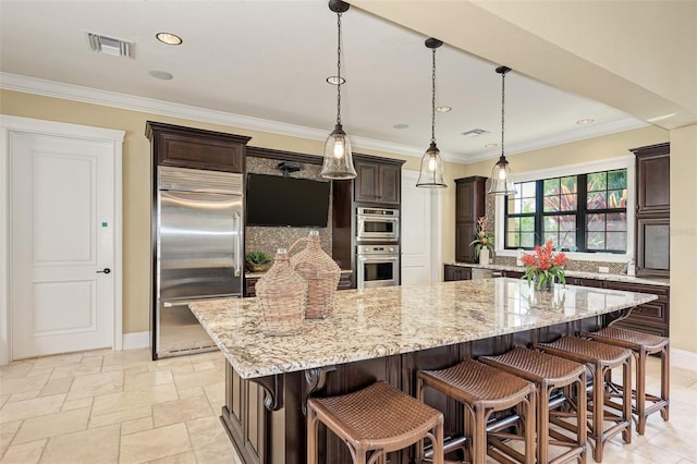 241 Marcheno Way, Nokomis, FL 34275 - kitchen with stainless steel appliances, dark brown cabinets, light stone countertops, baseboards, and ornamental molding