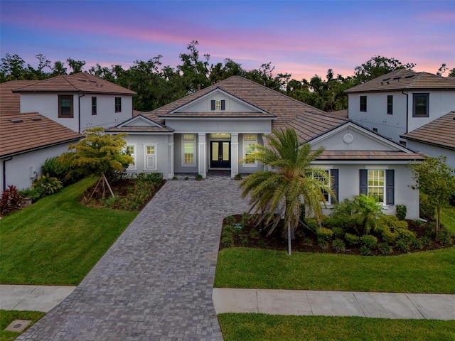 9048 Luna Ln, Sarasota, FL 34241 - view of front of home featuring french doors, stucco siding, driveway, and a front lawn