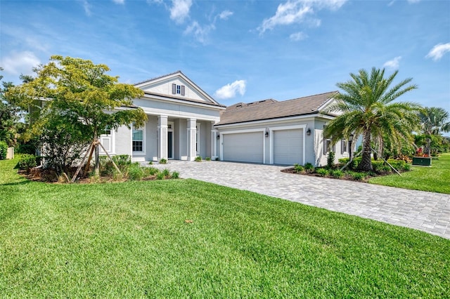 9048 Luna Ln, Sarasota, FL 34241 - neoclassical home with an attached garage, decorative driveway, a front yard, and stucco siding