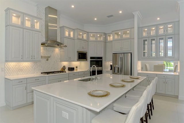 9048 Luna Ln, Sarasota, FL 34241 - kitchen with appliances with stainless steel finishes, wall chimney exhaust hood, a sink, an island with sink, and decorative backsplash