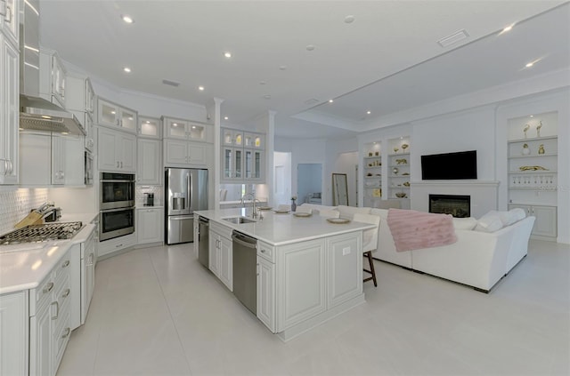 9048 Luna Ln, Sarasota, FL 34241 - kitchen featuring stainless steel appliances, wall chimney range hood, a sink, white cabinets, and light countertops