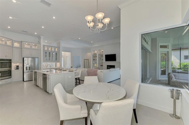 9048 Luna Ln, Sarasota, FL 34241 - dining room with a chandelier, a fireplace, crown molding, recessed lighting, and light tile patterned floors