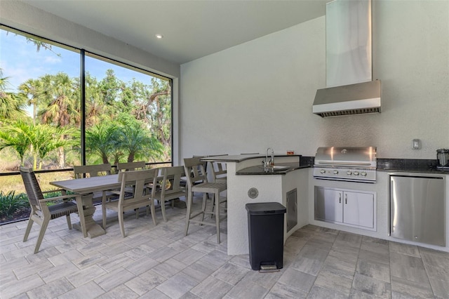 9048 Luna Ln, Sarasota, FL 34241 - kitchen featuring fridge, wall chimney range hood, dark countertops, and a peninsula