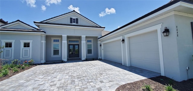 9048 Luna Ln, Sarasota, FL 34241 - view of front of house with french doors, decorative driveway, stucco siding, and a garage