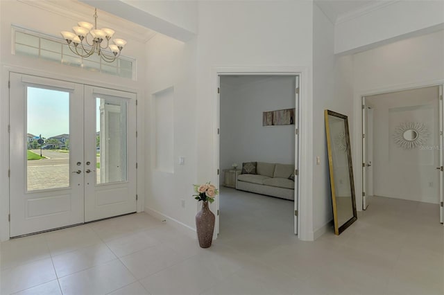 9048 Luna Ln, Sarasota, FL 34241 - foyer entrance with french doors, a high ceiling, a chandelier, baseboards, and ornamental molding