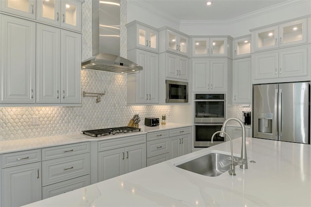 9048 Luna Ln, Sarasota, FL 34241 - kitchen featuring stainless steel appliances, wall chimney exhaust hood, white cabinets, a sink, and decorative backsplash