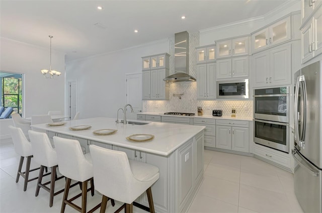 9048 Luna Ln, Sarasota, FL 34241 - kitchen with stainless steel appliances, wall chimney exhaust hood, a sink, a chandelier, and tasteful backsplash