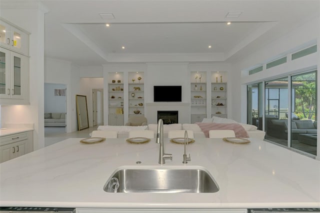 9048 Luna Ln, Sarasota, FL 34241 - kitchen featuring a sink, open floor plan, a raised ceiling, a fireplace, and light stone counters