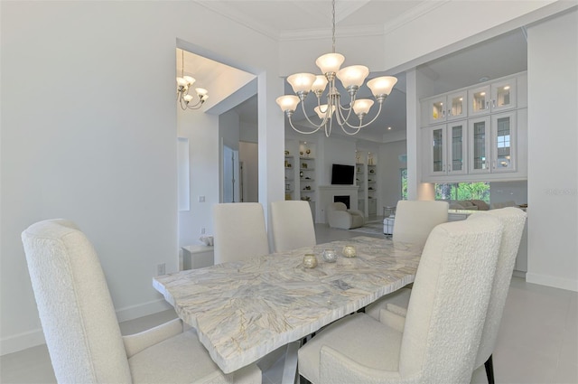 9048 Luna Ln, Sarasota, FL 34241 - dining area with a chandelier, crown molding, baseboards, and built in shelves