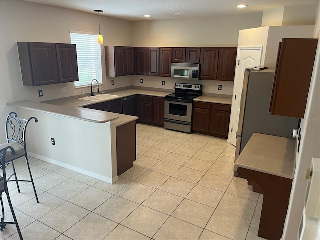 5966 Willows Bridge Loop, Ellenton, FL 34222 - kitchen with stainless steel appliances, a peninsula, light tile patterned floors, light countertops, and dark brown cabinetry