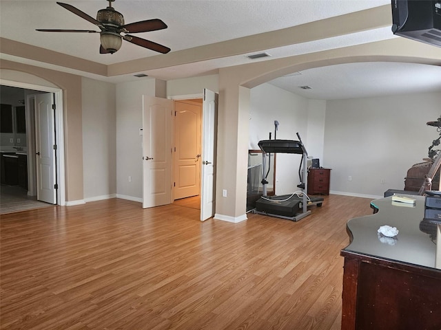 5966 Willows Bridge Loop, Ellenton, FL 34222 - workout room featuring arched walkways, ceiling fan, and light wood-style flooring