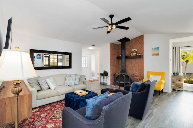 1439 Strada D Argento, Venice, FL 34292 - living room with a wood stove, wood finished floors, a ceiling fan, healthy amount of natural light, and vaulted ceiling