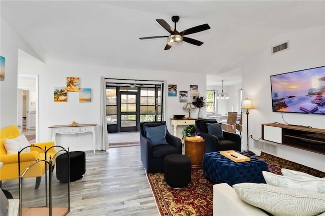 1439 Strada D Argento, Venice, FL 34292 - living area featuring lofted ceiling, light wood-type flooring, a ceiling fan, and a chandelier